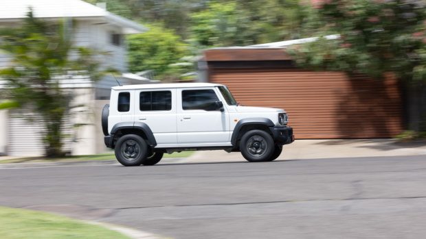 Suzuki Jimny XL 2024 fährt auf der Straßenseite