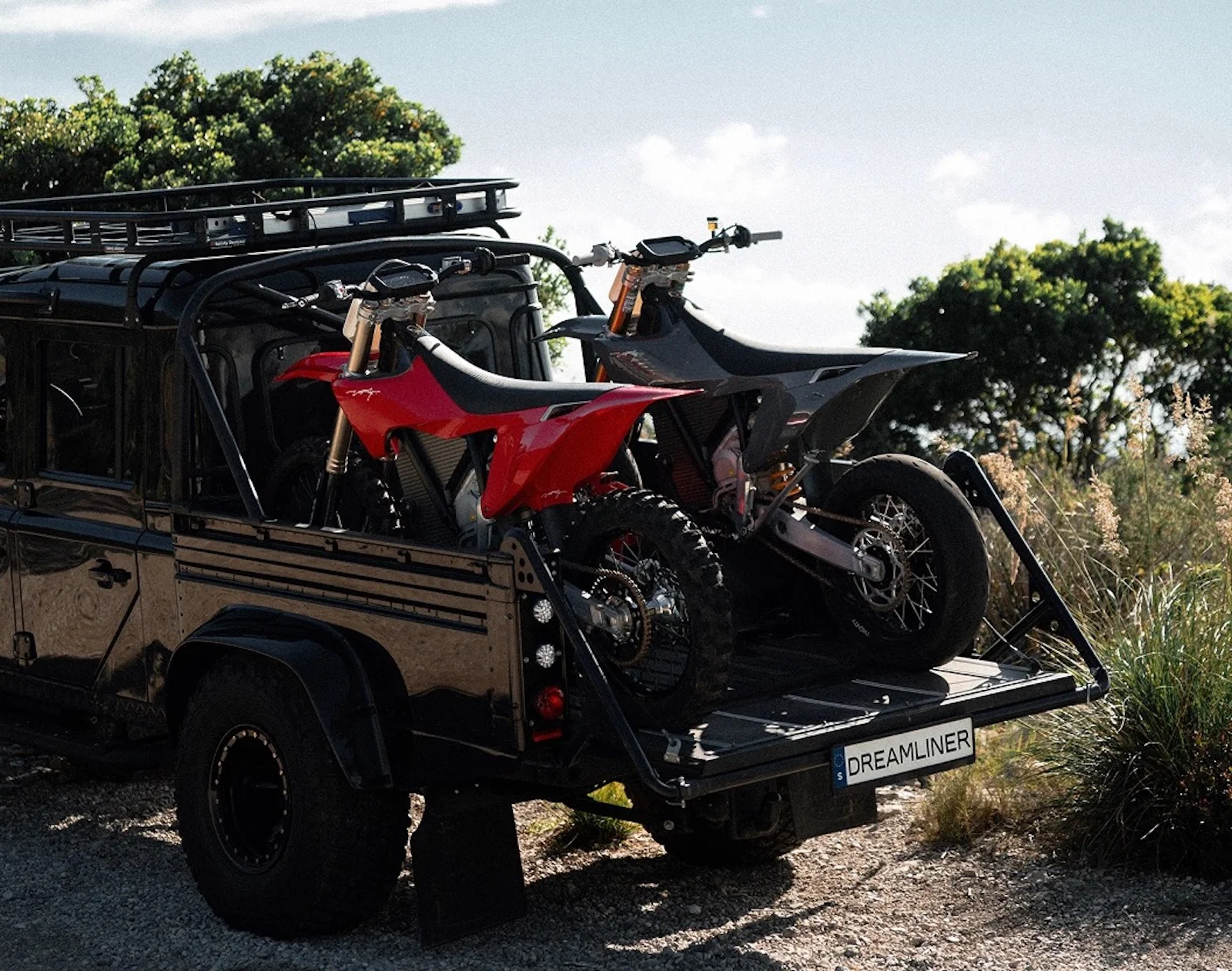Zwei Stark Varg-Dirtbikes auf der Ladefläche eines Pick-up-Land Rovers