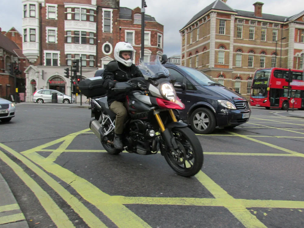 Motorradfahrer macht eine Kurve im Inneren eines Autos.