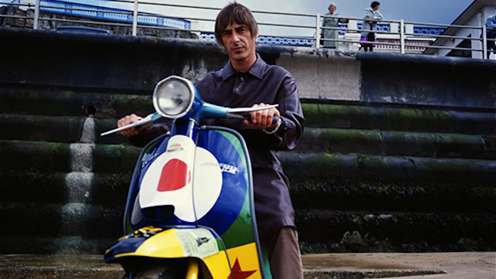 Paul Weller sitting on a his Lambretta Li150