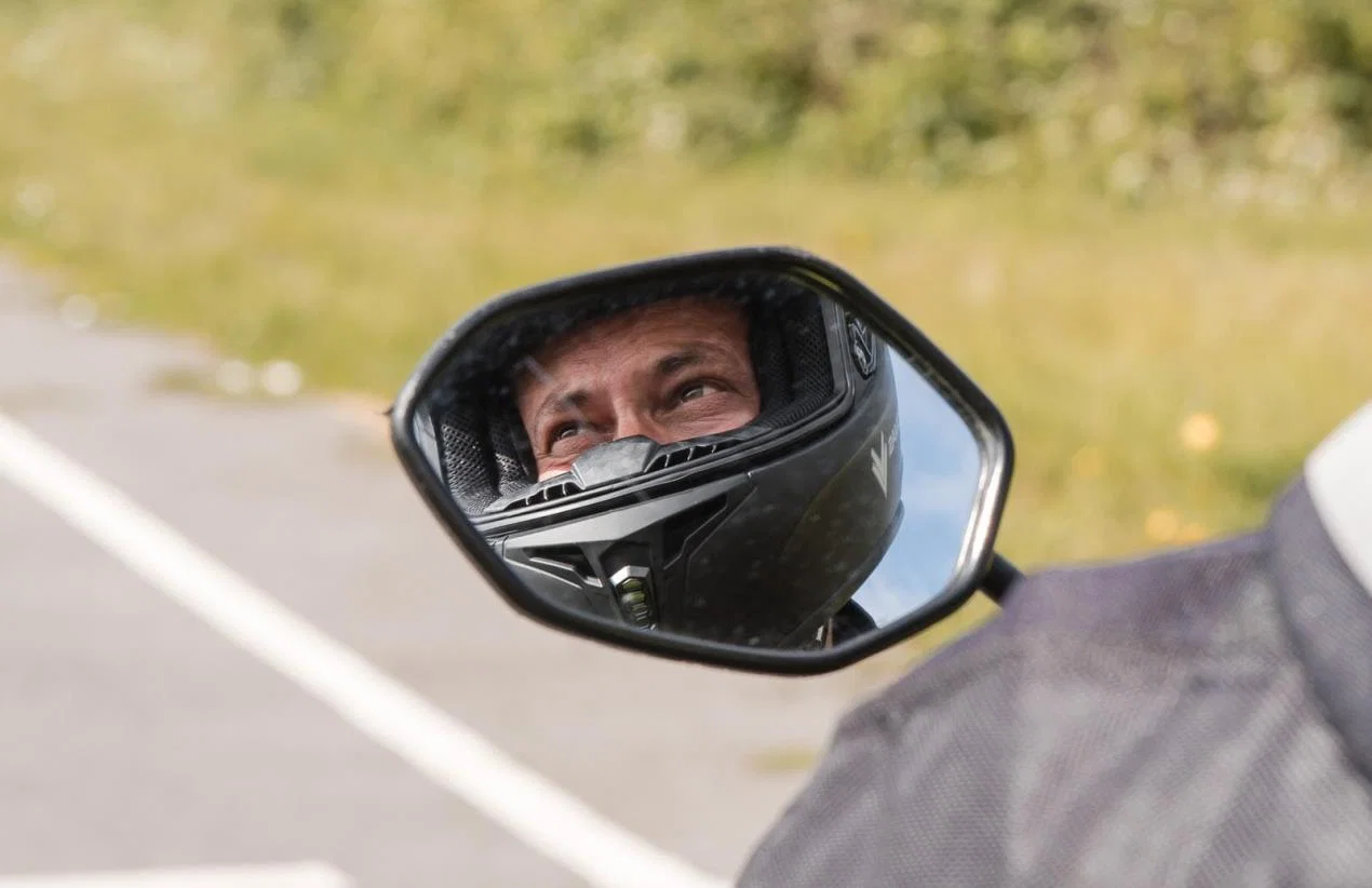 Das Gesicht eines Fahrers spiegelt sich im Rückspiegel